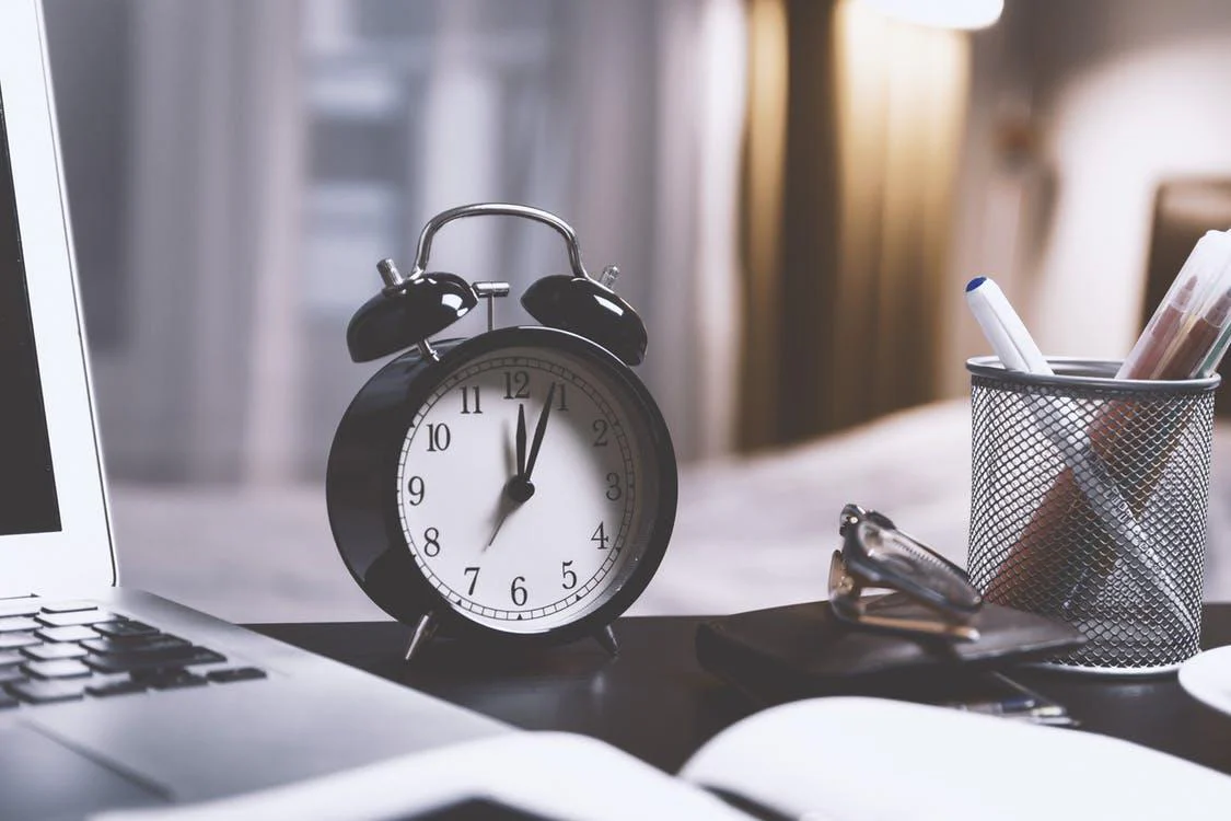An image of a traditional alarm clock on a desk